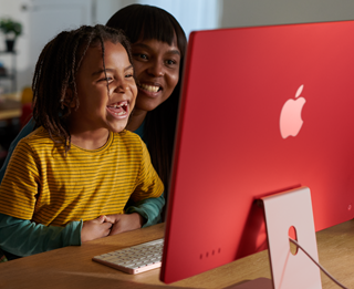 Família a rir enquanto vê uma série no iMac.